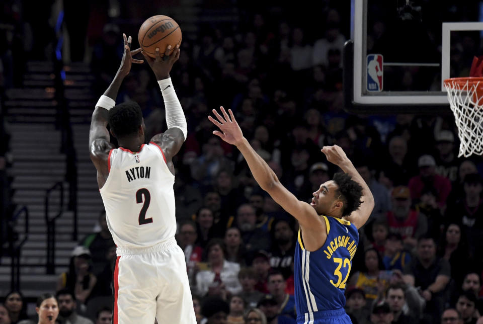 Portland Trail Blazers center Deandre Ayton (2) prepares to shoot a basket over Golden State Warriors forward Trayce Jackson-Davis, right, during the first half of an NBA basketball game in Portland, Ore., Thursday, April 11, 2024. (AP Photo/Steve Dykes)