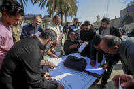 Supporters of the Shiite cleric Muqtada al-Sadr sign a pledge to stand against homosexuality or LGBTQ, outside a mosque in Kufa, Iraq, Friday, Dec. 2, 2022. Al-Sadr who announced his withdrawal from politics four months ago has broken a period of relative silence to launch an anti-LGBTQ campaign. (AP Photo/Anmar Khalil)