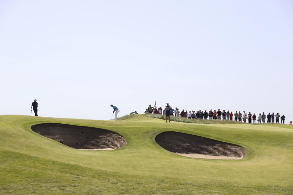 United States' Xander Schauffele, at centre, putts watched by Benjamin Hebert of France on the 10th green during the third round of the British Open Golf Championship at Royal St George's golf course Sandwich, England, Saturday, July 17, 2021. (AP Photo/Ian Walton)