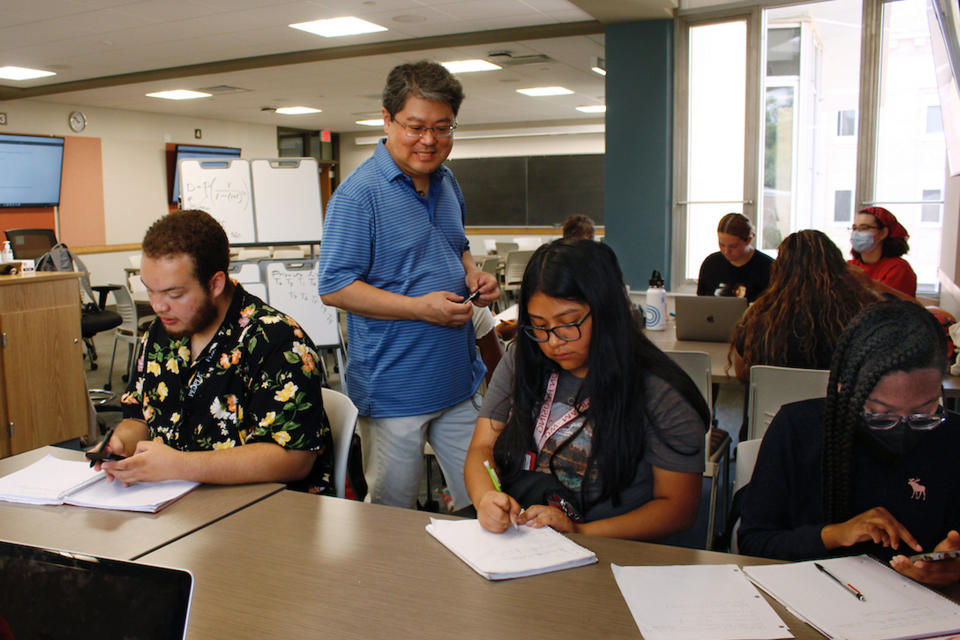 Instructor Oh Moon Kwon, standing, speaks to students during a math class that was part of an intense six-week summer bridge program for students of color and first-generation students at the University of Wisconsin, in Madison, Wis., July 27, 2022. At left is Angel Hope, who said he didn't feel ready for college after online classes in high school caused him fall behind but says the bridge classes made him feel more confident. Hundreds of thousands of recent graduates are heading to college this fall after spending more than half their high school careers dealing with the upheaval of a pandemic. (AP Photo/Carrie Antlfinger)