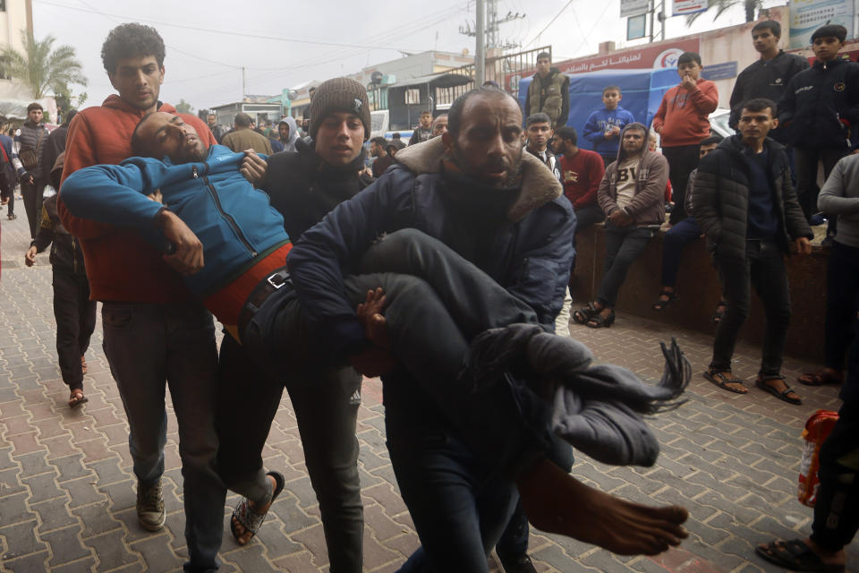 Palestinians wounded in the Israeli bombardment of the Gaza Strip is carried into Nasser hospital in Khan Younis, Thursday, Dec. 14, 2023. (AP Photo/Mohammed Dahman)
