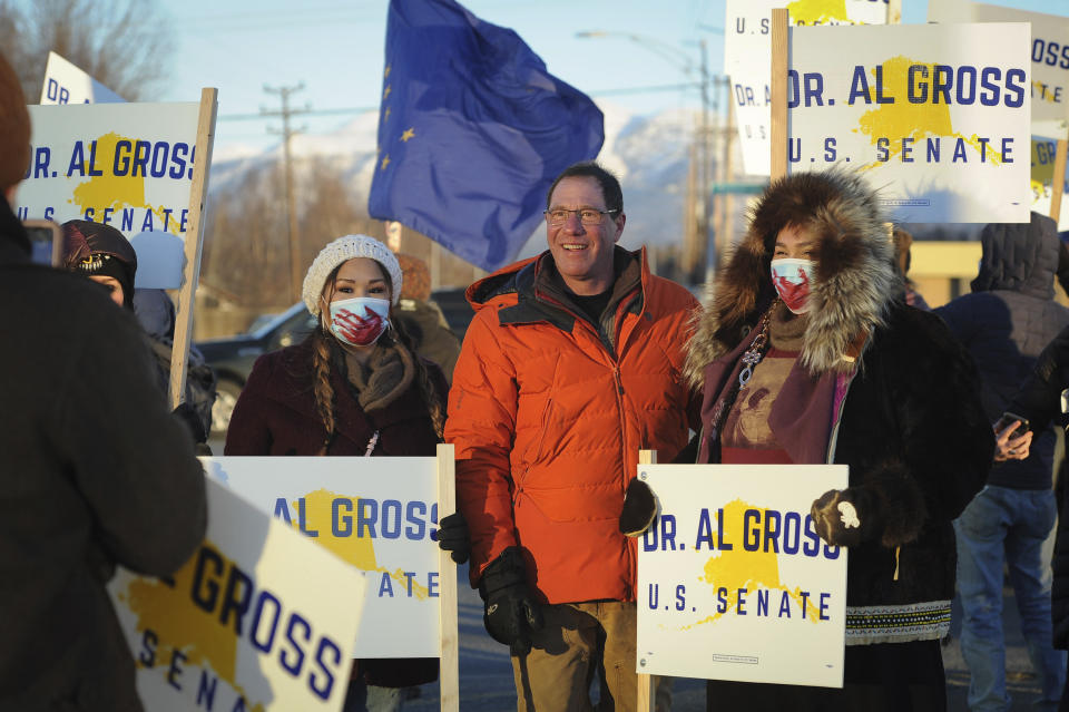 Dr. Al Gross, center, pauses for a photo with supporters during a sign-waving along Seward Highway, on Election Day, Tuesday, Nov. 3, 2020, in Anchorage, Alaska. Gross, an independent candidate for the U.S. Senate, is battling incumbent Republican Sen. Dan Sullivan. (AP Photo/Michael Dinneen)