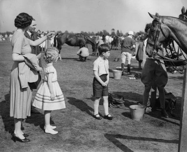 Queen Elizabeth II with Prince Charles and Princess Anne visiting the polo ponies during a break in the polo tournament, in which the Duke of Edinburgh was playing at Smith’s Lawn in Windsor Great Park in 1956