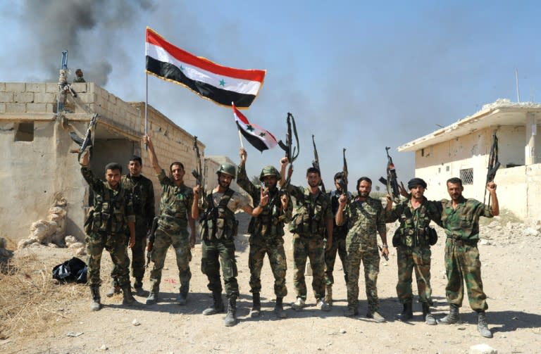 Syrian forces celebrate after capturing Atshan village as part of a major ground offensive in central Hama province, on October 11, 2015