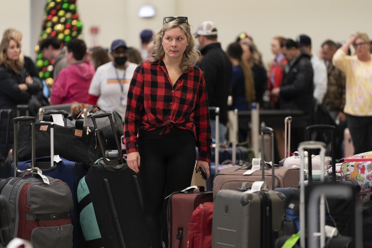 Ashlyn Harmon of New Orleans searches for her Southwest Airlines bags amongst hundreds of others at Midway International Airport as Southwest continues to cancel thousands of flights across the country Wednesday, Dec. 28, 2022, in Chicago. Harmon said her family's initial Southwest flight was cancelled on Christmas so they rebooked on American Airlines, although Southwest still shipped their bags to Midway. "We rebooked ourselves," she said. "I figure we can deal with refunds and all of that when we get back." She was searching for her own bag, which contains medication for her young son. (AP Photo/Erin Hooley)