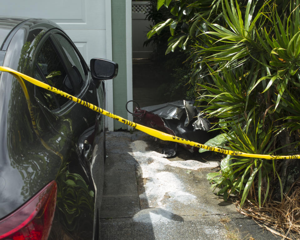 Debris lies on the ground where parts of a helicopter hit a parked car. Source: AP