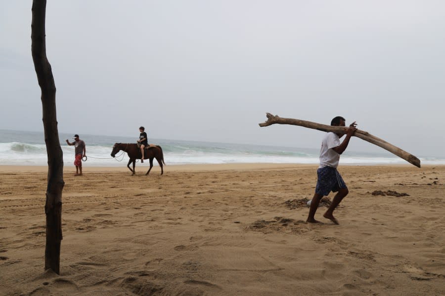 A tourist rides a horse at a beach in Acapulco, Mexico, Tuesday, Oct. 24, 2023. Hurricane Otis has strengthened from tropical storm to a major hurricane in a matter of hours as it approaches Mexico’s southern Pacific coast where it was forecast to make landfall near the resort of Acapulco early Wednesday. (AP Photo/Bernardino Hernandez)