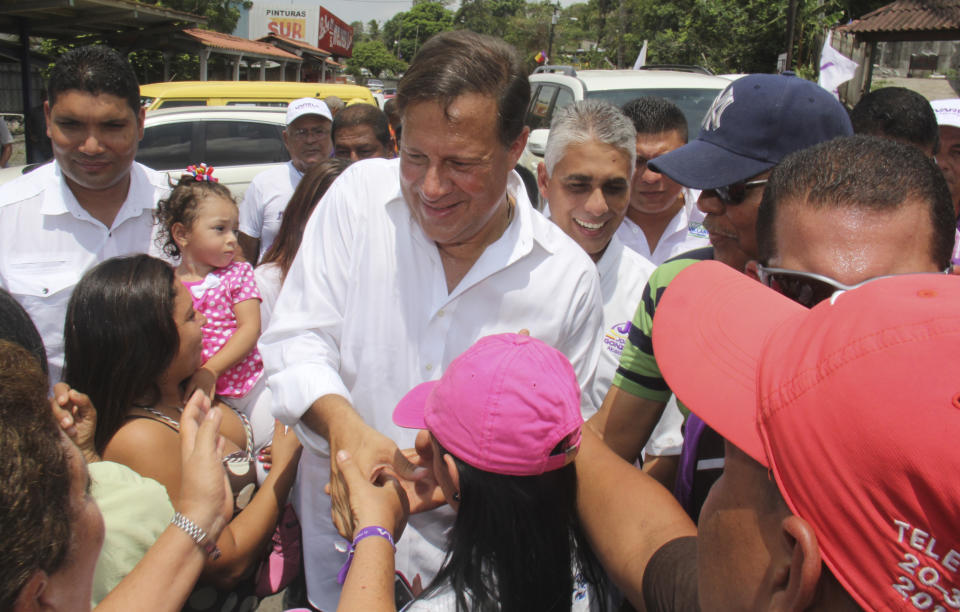 Juan Carlos Varela, presidential candidate for the Panamenista Party greats people after casting his vote during general election in Pese, Panama, Saturday, May 3, 2014. Panamanians are choosing President Ricardo Martinelli's successor in a three-way dogfight marked more by ugly personality clashes than any deep disagreements over the way forward for Latin America's standout economy. (AP Photo/STR)