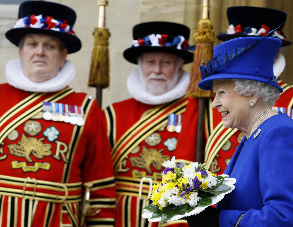 Britain's Queen Elizabeth II smiles as she walks past Yeoman of the Guard, after attending the Maundy service, at Christ Church Cathedral in Oxford, England, Thursday, March 28, 2013. During the service the Queen distributed the Maundy money to 87 women and 87 men, one for each of The Queen’s 87 years. Each recipient receives two purses, one red and one white. The red purse will contain a 5 pound coin and 50 pence coin commemorating the 60th anniversary of The Queen’s Coronation. The white purse will contain uniquely minted Maundy Money. This takes the form of silver one, two, three and four penny pieces, the sum of which equals the number of years the Monarch has years of age. This year there will be 87 pennies worth distributed. (AP Photo/Kirsty Wigglesworth, Pool)