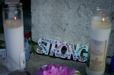 Candles burn as part of a memorial at the scene of Sunday morning’s mass shooting in Dayton