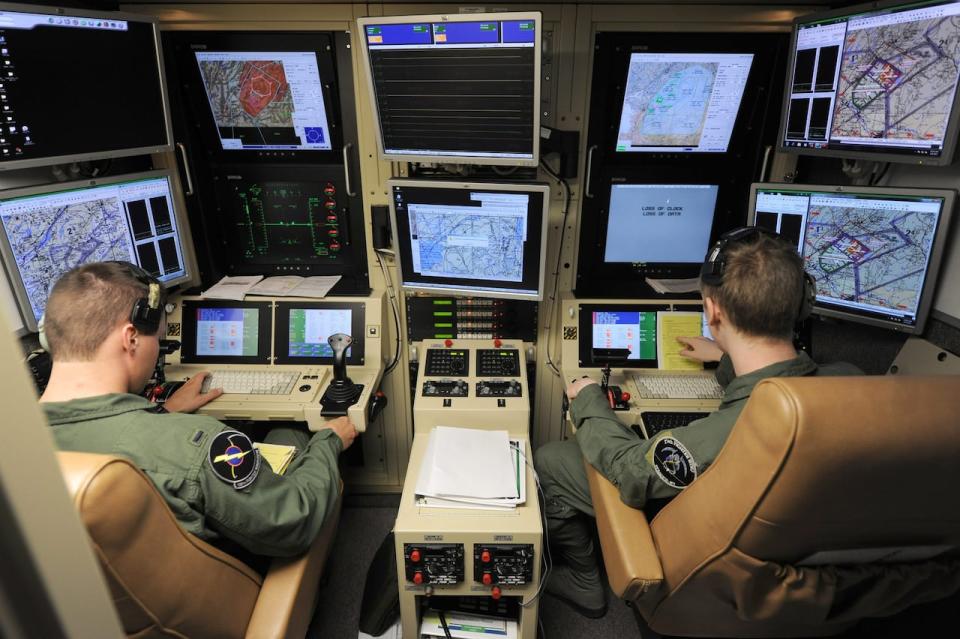 This photo taken June 6, 2012 and provided by the Defence Department shows a student pilot and sensor operator man the controls of a MQ-9 Reaper in a ground-based cockpit during a training mission flown from Hancock Field Air National Guard Base, Syracuse, New York. At the Air Force Academy in Colorado Springs, becoming a fighter pilot is still a hotly coveted goal. But slowly, a culture change is taking hold. Initially snubbed as second-class pilot-wannabes, the airmen that remotely control America's arsenal of lethal drones are gaining stature and securing a permanent place in the Air Force.  (AP Photo/, Defense Department)