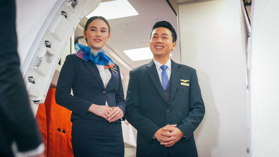 Air stewardess welcome in front of airplane