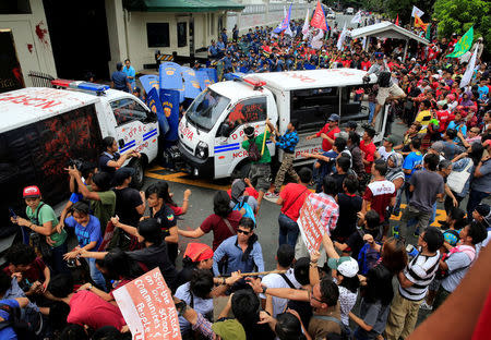 Protesters try to trash a police mobile patrol vehicle as they join various activist and Indigenous People's (IP) groups in a protest against the continuing presence of U.S. troops in the Philippines in front of the U.S. Embassy in metro Manila, Philippines October 19, 2016. REUTERS/Romeo Ranoco