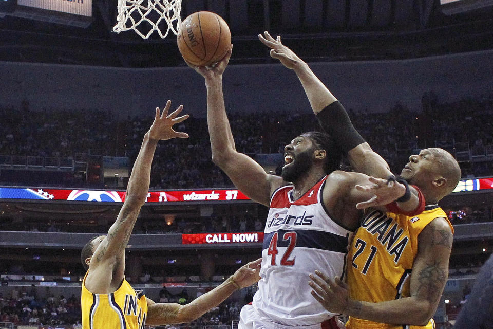 Washington Wizards forward Nene (42) of Brazil shoots between Indiana Pacers guard George Hill and Indiana Pacers forward David West (21) during the second half of Game 3 of an Eastern Conference semifinal NBA basketball playoff game in Washington, Friday, May 9, 2014. The Pacers won 85-63. (AP Photo/Alex Brandon)