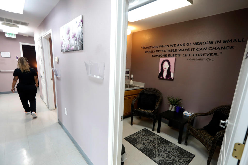 Clinical coordinator Jaunita Loza walks down a hallway past a room named after Margaret Cho at the Whole Woman's Health clinic in Fort Worth, Texas, Wednesday, Sept. 4, 2019. Marva Sadler, director of clinical services, said that the entire clinic has quotes and pictures throughout with various rooms named after "Women of Power." (AP Photo/Tony Gutierrez)