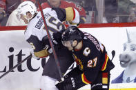 Vegas Golden Knights' Pavel Dorofeyev, left, works against Calgary Flames' Matt Coronato during the second period of an NHL hockey game Thursday, March 14, 2024, in Calgary, Alberta. (Larry MacDougal/The Canadian Press via AP)