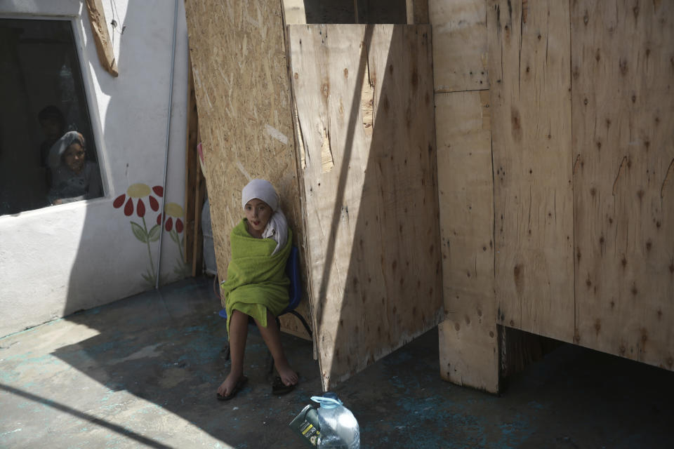 A migrant child sits wrapped in a towel after showering at a shelter in Ciudad Juarez, Mexico, Saturday, Sept. 4, 2021. (AP Photo/Christian Chavez)