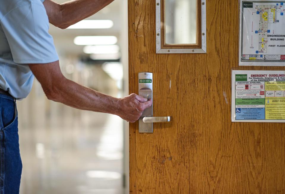 Steve Guenther of Nielsen Commercial Construction tests out the new lockset he replaced on a classroom door in the Engineering Building on the campus of Michigan State University, Tuesday, Aug. 8, 2023. The new locksets are one of the new security protocols implemented by MSU following last February's campus shooting and allow those within classrooms to manually secure doors from the inside without a key.