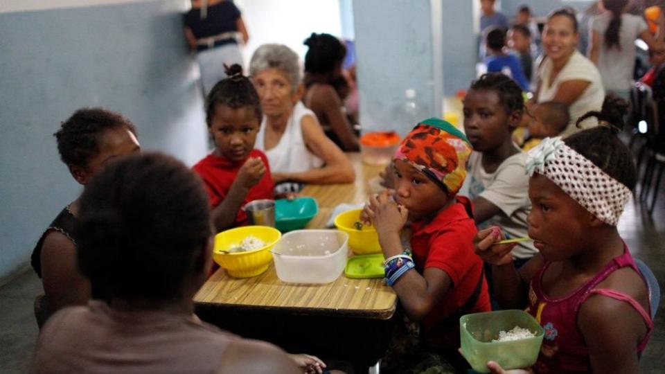 Niños almorzando en un comedor comunitario en Petare (Caracas).