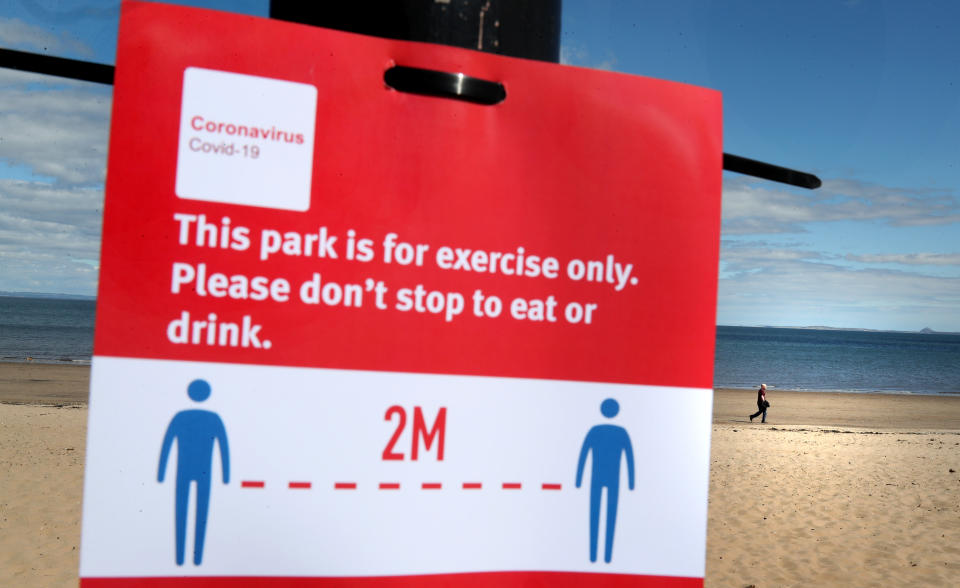 Members of the public walk along the beach front at Portobello as the UK continues in lockdown to help curb the spread of the coronavirus.