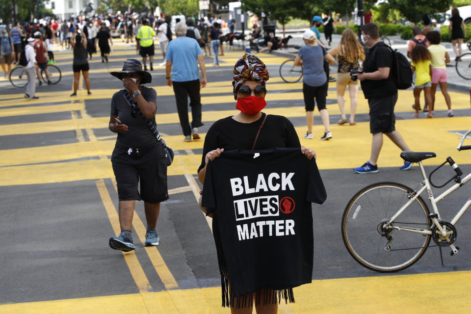 Nickia Wood stands with a Black Lives Matter shirt as people gather near the White House, Saturday, June 6, 2020, in Washington, before scheduled protests over the death of George Floyd, who died after being restrained by Minneapolis police officers. (AP Photo/Patrick Semansky)