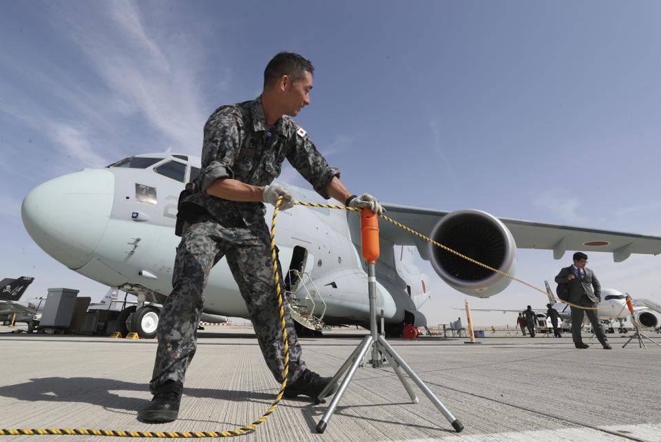 A Japanese crew fixes the rope around the Kawasaki C-2 transport aircraft during the opening day of Dubai Airshow in Dubai, United Arab Emirates, Sunday, Nov. 17, 2019. The biennial Dubai Airshow has opened as major Gulf airlines reign back big-ticket purchases after a staggering $140 billion in new orders were announced at the 2013 show before global oil prices collapsed. (AP Photo/Kamran Jebreili)