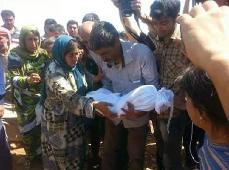 Father of Aylan Kurdi (C), (also know as Aylan Shenu), a three-year-old boy who drown off Turkey, holds the child his funeral in Kobane, Syria on September 4, 2015