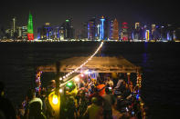 People dance in a wooden boat at the Corniche sea promenade, two days ahead of the World Cup kick off, in Doha, Qatar, Friday, Nov. 18, 2022. (AP Photo/Francisco Seco)