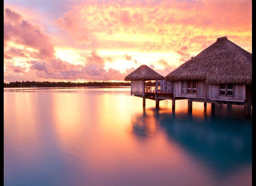You’ll probably never want to leave (ever) when you set foot in your villa at <a href="http://www.destinationweddingmag.com/gallery/bucket-list-honeymoon-destinations-overwater-bungalow-tahiti-bora-bora?src=SYN&dom=huffpo" target="_hplink">The St. Regis Bora Bora Resort</a>. Personal butlers will deliver whatever your heart desires and swimming is as easy as diving off the swim platform into the clear, bathlike waters below. If you do emerge, the resort’s sprawling grounds, made smaller with beach-cruiser bikes, are lush and fringed with palm trees and beaches. The spa is tucked away on an island in the middle of its own lagoon, where tropical fish and corals were raised in a protected environment, making it an ideal snorkel spot. <em>Photo by Zach Stovall</em>  <strong>Related: <a href="http://www.destinationweddingmag.com/article/Overwater-Bungalow-Honeymoons-Bora-Bora-Tahiti?src=SYN&dom=huffpo" target="_hplink">More overwater bungalows in Tahiti</a></strong>