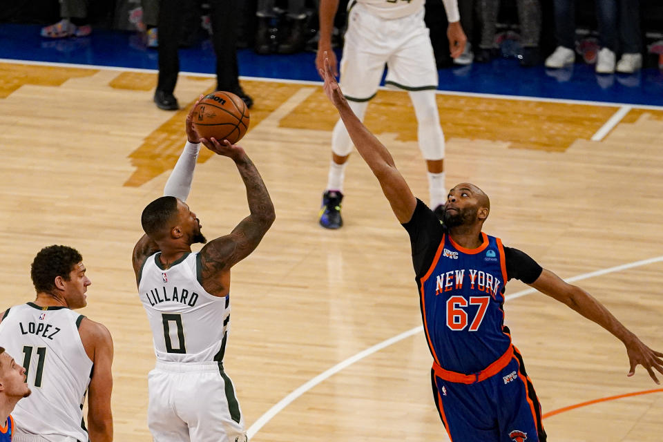 Milwaukee Bucks guard Damian Lillard (0) shoots over New York Knicks forward Taj Gibson (67) during the first half of an NBA basketball game in New York, Saturday, Dec. 23, 2023. (AP Photo/Peter K. Afriyie)