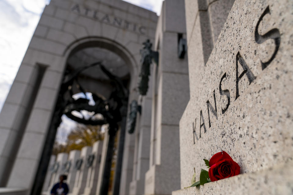 A single rose is left at the Kansas state pillar, the state which Bob Dole long represented in the Senate, at the World War II Memorial on the National Mall in Washington, Sunday, Dec. 5, 2021. Dole, who overcame disabling war wounds to become a sharp-tongued Senate leader from Kansas, a Republican presidential candidate and then a symbol and celebrant of his dwindling generation of World War II veterans, has died. He was 98. His wife, Elizabeth Dole, posted the announcement Sunday, on Twitter. (AP Photo/Andrew Harnik)