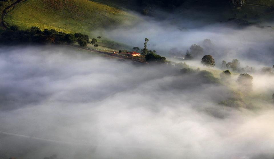 Fog sourrounds a farm in the mountains in Goncalves, in the state of Minas Gerais in southwestern Brazil, April 18, 2014. REUTERS/Paulo Whitaker (BRAZIL - Tags: ENVIRONMENT TPX IMAGES OF THE DAY)