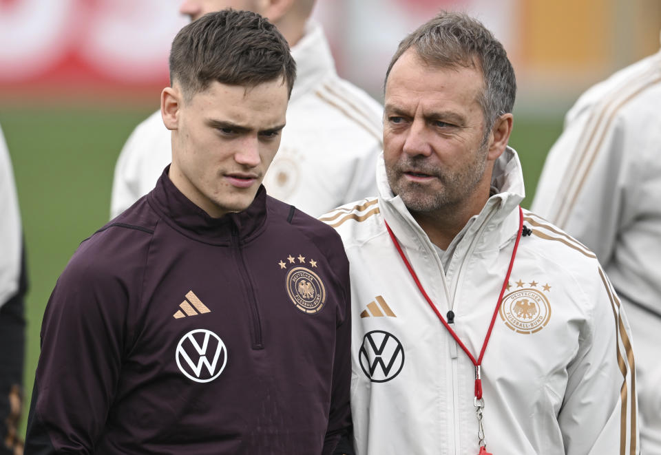 Germany's National coach Hansi Flick, right, talks to Florian Wirtz during the national team's training session at the DFB campus prior to the international match between Germany and Peru, in Frankfurt, Germany, Wednesday March 22, 2023. (Arne Dedert/dpa via AP)