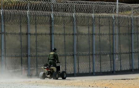 FILE PHOTO: A U.S. border patrol agent patrols the U.S. and Mexico border fence in San Ysidro, California, U.S. April 18, 2017. REUTERS/Mike Blake