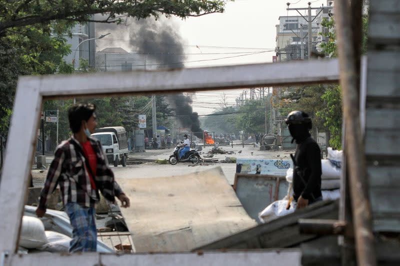 Demonstrators gather behind barricades during a protest against the military coup in Mandalay