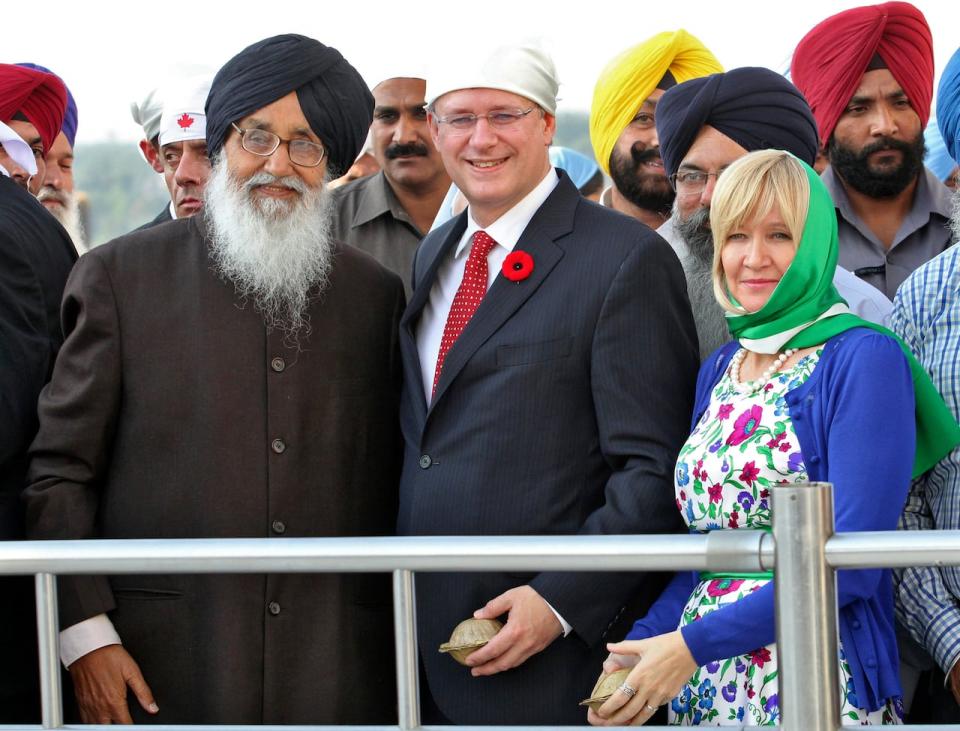 Canadian Prime Minister Stephen Harper (C) and his wife Laureen (front R) pose for a picture with Punjab's Chief Minister Parkash Singh Badal (front L) during their visit to a Gurudwara or Sikh temple at Anandpur Sahib, in the northern Indian state of Punjab November 7, 2012. A trend toward greater protectionism was pushing the world toward a prolonged recession, Harper said on Wednesday, although he added an economic catastrophe could be averted. REUTERS/Ajay Verma (INDIA - Tags: POLITICS BUSINESS) - GM1E8B71R2K01