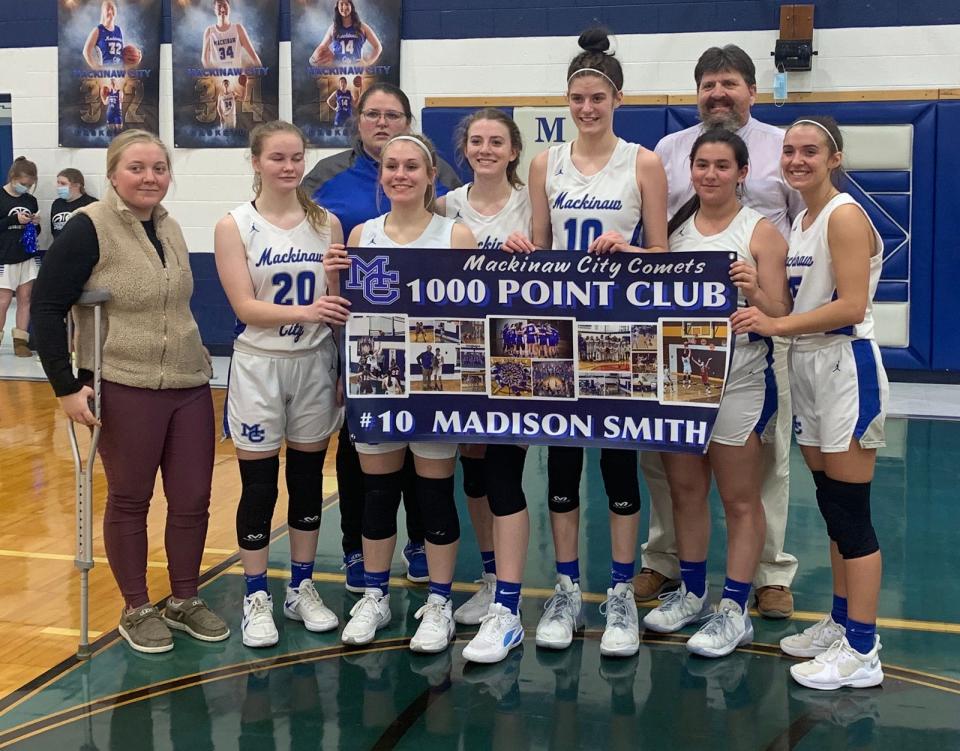 Mackinaw City's Madison Smith stands with teammates and coaches following Thursday's win over Ellsworth. Smith surpassed 1,000 career points in the win over the Lancers.