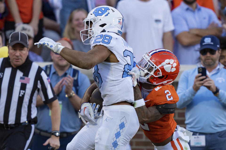 Clemson cornerback Nate Wiggins (2) forces a fumble by North Carolina running back Omarion Hampton (28) just before the goal line during the first half of an NCAA college football game Saturday, Nov. 18, 2023, in Clemson, S.C. (AP Photo/Jacob Kupferman)