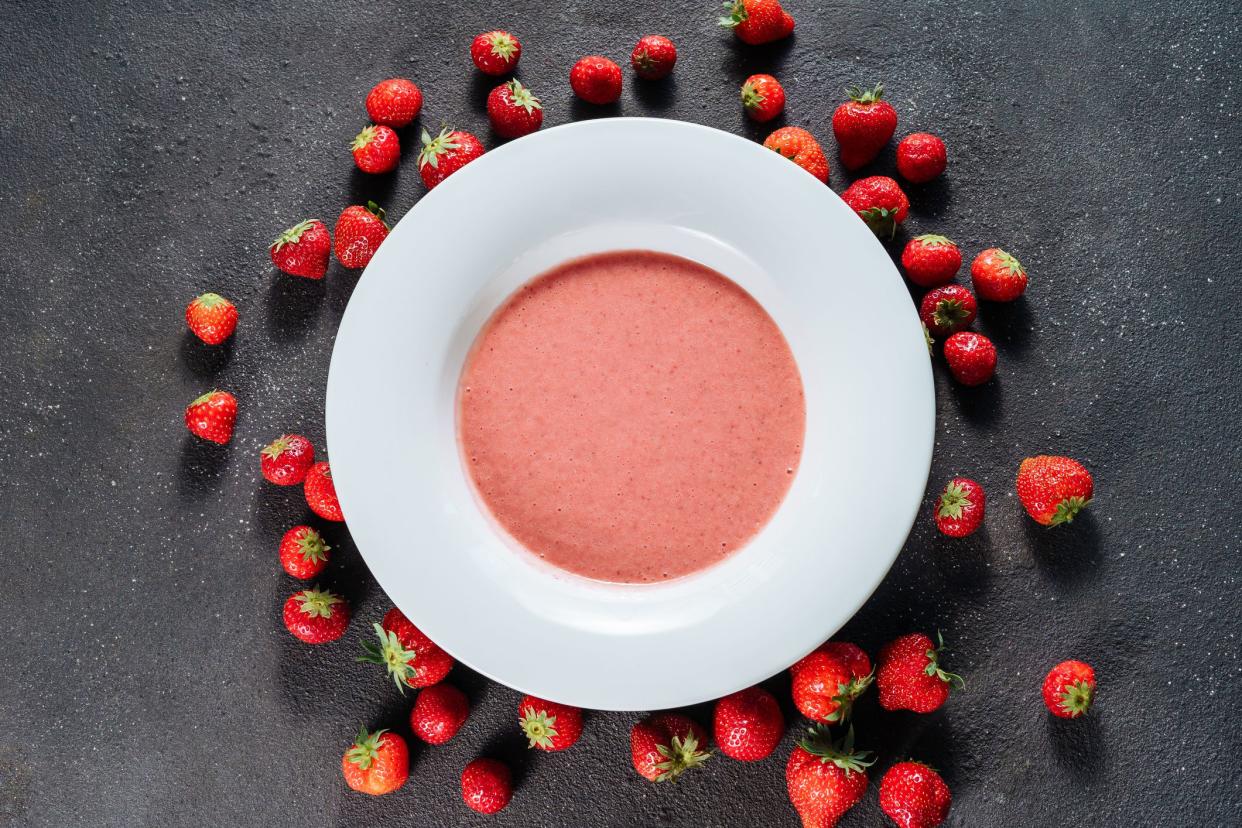 Strawberry Gazpacho Delicious Sweet Dish Top View. Tasty Cold Soup Made of Blended Natural Red Ripe Berries in White Plate Isolated on Black Background. Refreshing and Cool Classic Spanish Cuisine