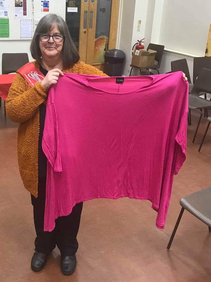 Childs holds up her old size 24 clothes. (Lisa Childs/SWNS)