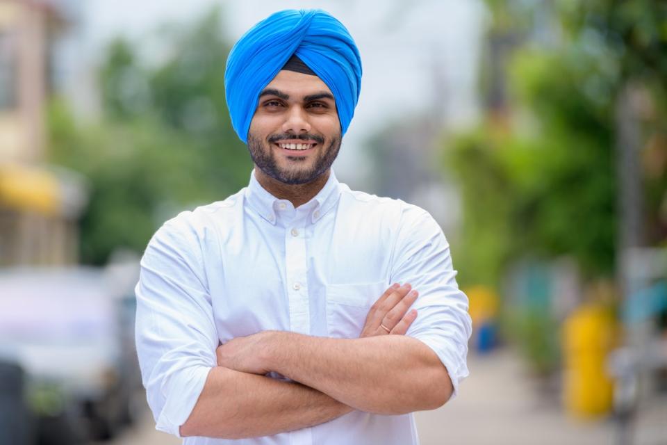 Someone in a white shirt with crossed arms is smiling. 