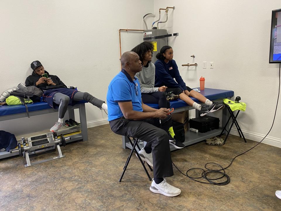 Randall Cunningham, in blue, and Vashti Cunningham, in gray, watch video of practice at the Cunningham compound in Las Vegas. (Yahoo Sports)