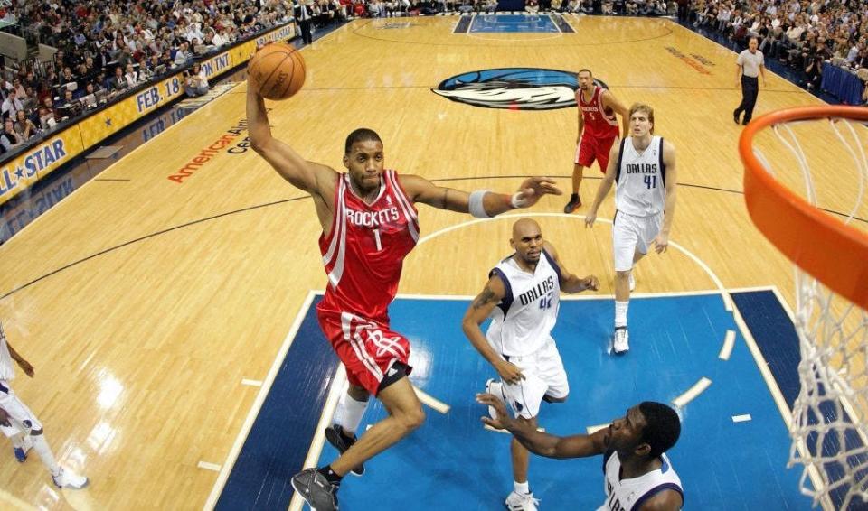 DALLAS - JANUARY 12:  Forward Tracy McGrady #1 of the Houston Rockets makes a windmill dunk against the Dallas Mavericks on January 12, 2005 at the American Airlines Center in Dallas, Texas. The Rockets defeated the Mavericks 124-114.  NOTE TO USER: User expressly acknowledges and agrees that, by downloading and/or using this Photograph, user is consenting to the terms and conditions of the Getty Images License Agreement.  (Photo by Ronald Martinez/Getty Images)