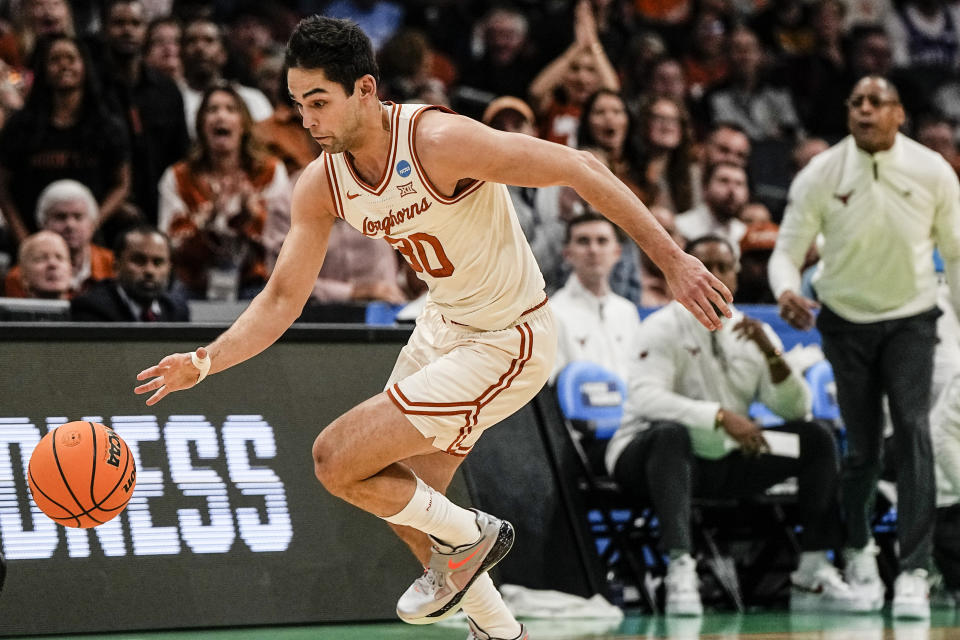 Texas forward Brock Cunningham (30) moves the ball after a steal against Colorado State during the first half of a first-round college basketball game in that NCAA Tournament, Thursday, March 21, 2024, in Charlotte, N.C. (AP Photo/Mike Stewart)