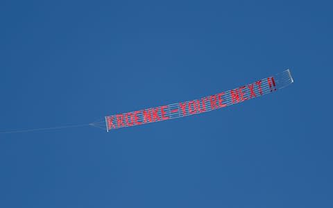  banner in reference to Arsenal owner Stan Kroenke being flown over the stadium - Credit: Reuters