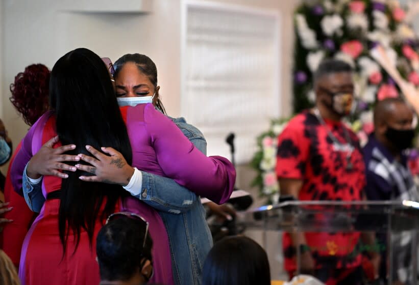 Inglewood, California January 27, 2022: Mourners hug at funeral services for 16-year-old Tioni Theus in Los Angeles Thursday. The body of Theus was found near the 110 freeway with a gun shot wound in the neck. (Wally Skalij/Los Angeles Times)