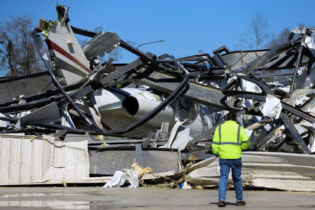 A man looks at a damaged Bombardier Challenger 350 jet at the Eufaula Municipal Airport, after a string of tornadoes, in Eufaula, Alabama, U.S., March 5, 2019. REUTERS/Elijah Nouvelage