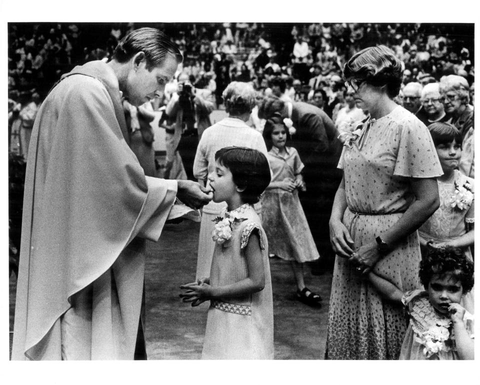 Bishop Matthew Clark gives communion to his niece Helen Early.