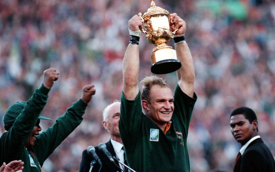 South Arican President Nelson Mandela, left, cheers as Springbok Rugby captain Francois Pienaar holds the trophy in 1995