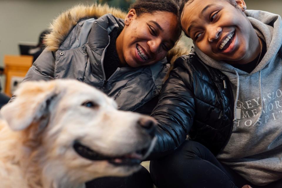 Michigan State University seniors Trinity Belcher, right, and Mia Johnson share a laugh while reacting to therapy dog Jake making a face as they scratch him as students spend time petting therapy dogs in the Main Library on the campus in East Lansing on Friday, Feb. 17, 2023. Therapy dogs were on campus to help students/faculty in the aftermath of the mass shooting on campus that left three students dead and five in critical condition.